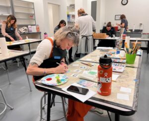Photo of several adults making art at the Becoming Arts Third Thursday Art Session.